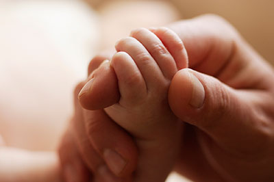 a close up of a baby's hand holding a finger 